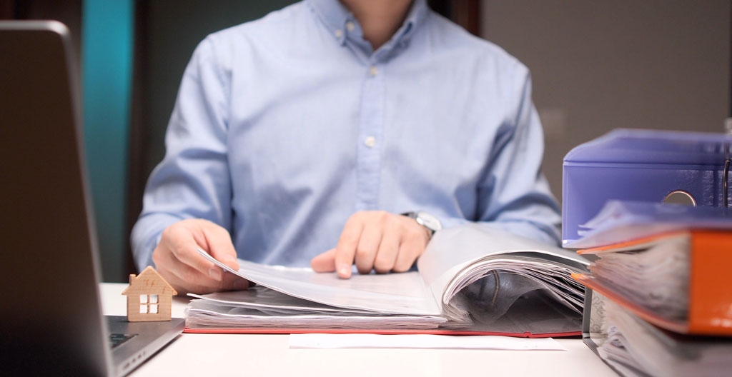 Trois groupes de documents administratifs français organisés sur table blanche : pièces d'identité et justificatif de domicile, bulletins de salaire et avis d'imposition, compromis de vente avec tampon officiel